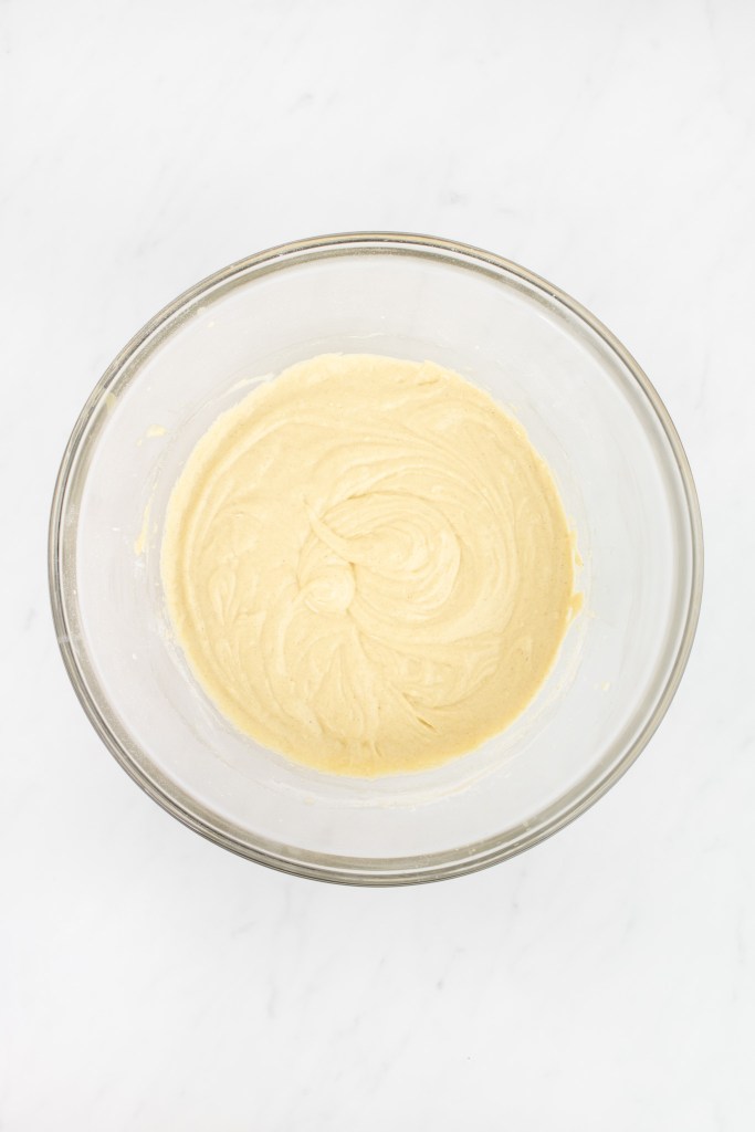 A glass bowl filled with smooth, light tres leches cake batter, before the egg whites are added.